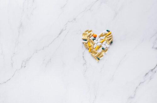 a heart shaped pills and medicines on a marble surface