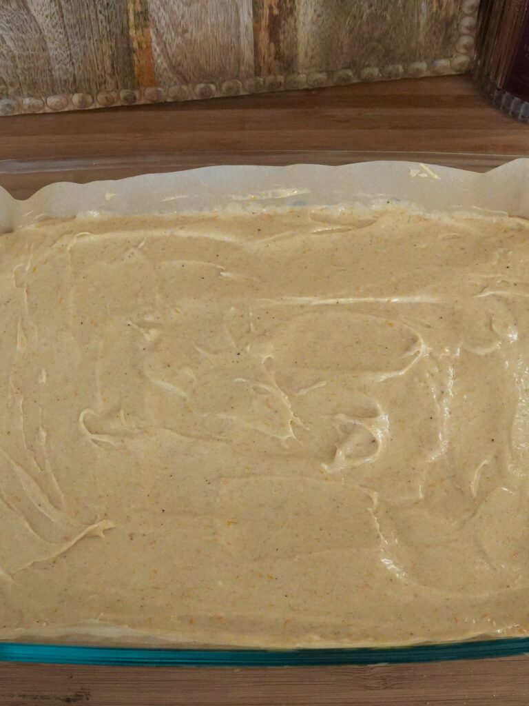 Pour the sweet potato filling over the unbaked cake crust, spreading it evenly toward the corners with an offset spatula.